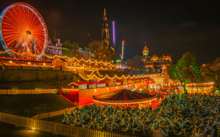 Festlich beleuchtetes Edinburgh Winter Festival mit funkelnden Lichterketten, einem leuchtenden Riesenrad und stimmungsvoller Weihnachtsmarkt-Atmosphäre in der historischen Altstadt.
