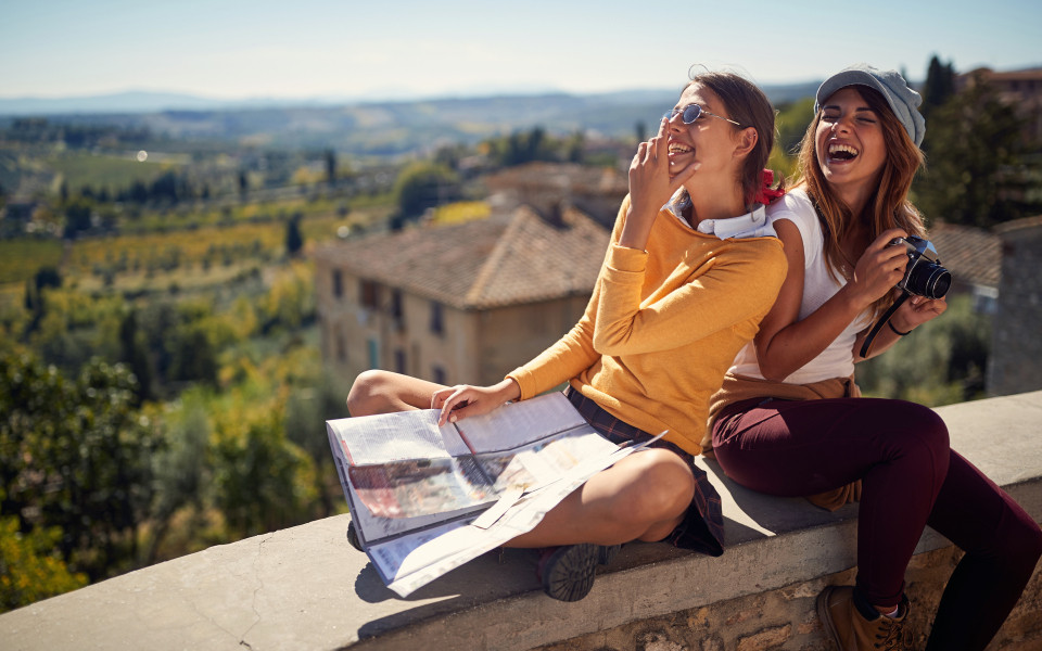 Freunde sitzen auf Stadtmauer mit Stadtplan
