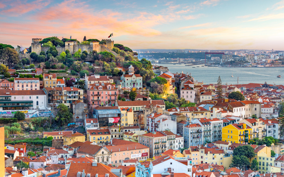Panoramablick auf Funchal auf Madeira mit bunten H&auml;usern, &uuml;ppiger Vegetation und dem Atlantik im Hintergrund, stimmungsvoll beleuchtet im warmen Abendlicht.